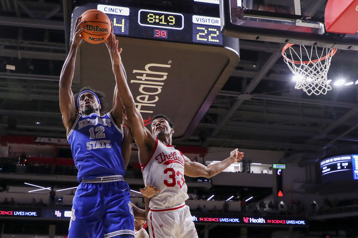 Jan 22, 2023; Cincinnati, Ohio, USA; Memphis Tigers forward DeAndre Williams (12) battles for the ball against Cincinnati Bearcats forward Ody Oguama (33) in the first half at Fifth Third Arena. Mandatory Credit: Katie Stratman-USA TODAY Sports